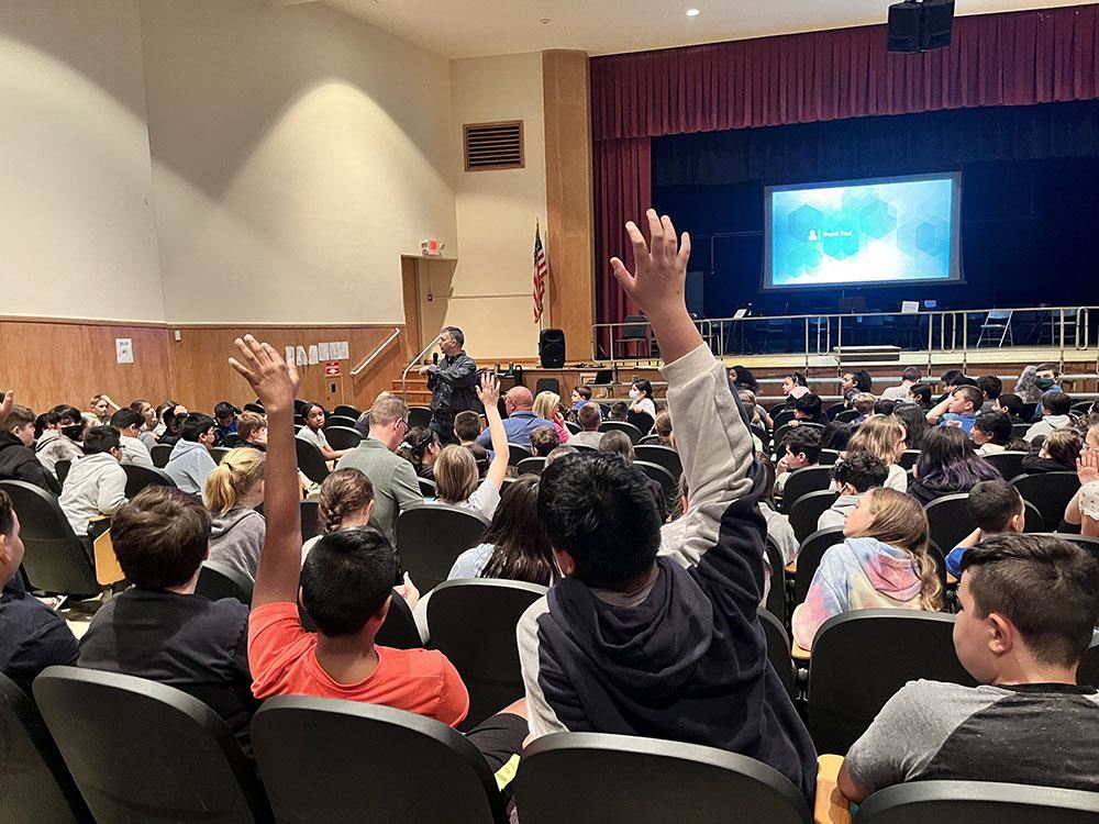  students raise their hands during Autism Speaks presentation